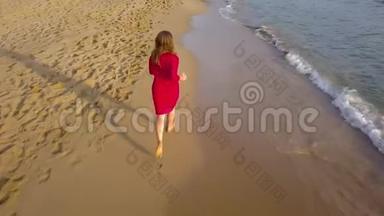 一个女人赤脚在潮湿的沙滩上奔跑的俯视图。 海浪冲刷着沙滩上的脚印